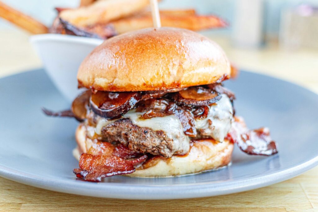 A mouthwatering burger with bacon, mushrooms, and cheese on a toasted bun in Williamson County, Tennessee.