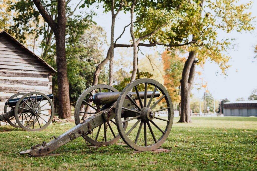 How to Explore Franklin's History in 3 Hours or 3 Days Two antique cannons with wooden wheels rest on a grassy field near a log cabin in Williamson County, Tennessee.