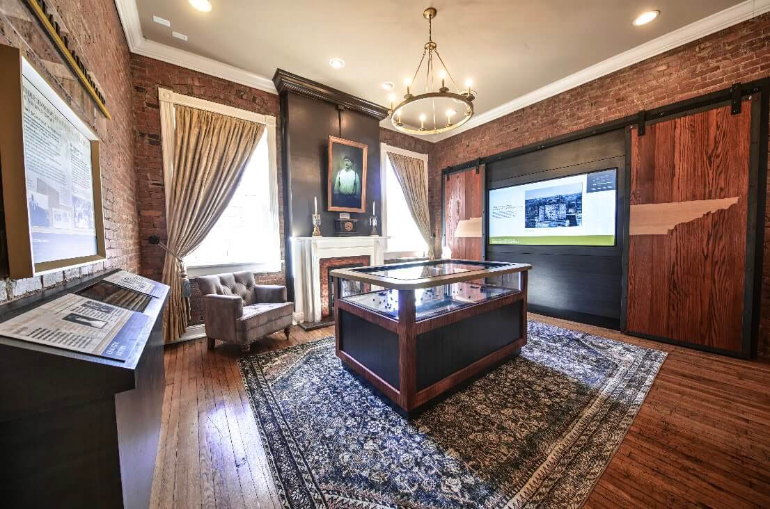 5 Reasons You Need to Check Out Franklin's Amazing New History & Culture Center A historic room with a fireplace, wooden floor, and a central display table in Williamson County, Tennessee.