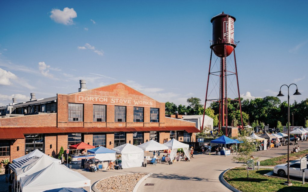 panorama of outdoor farmers market with water tower in background