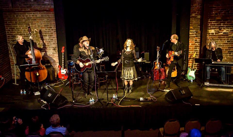 A country music band performs on stage with guitars, a double bass, and a keyboard in Williamson County, Tennessee.