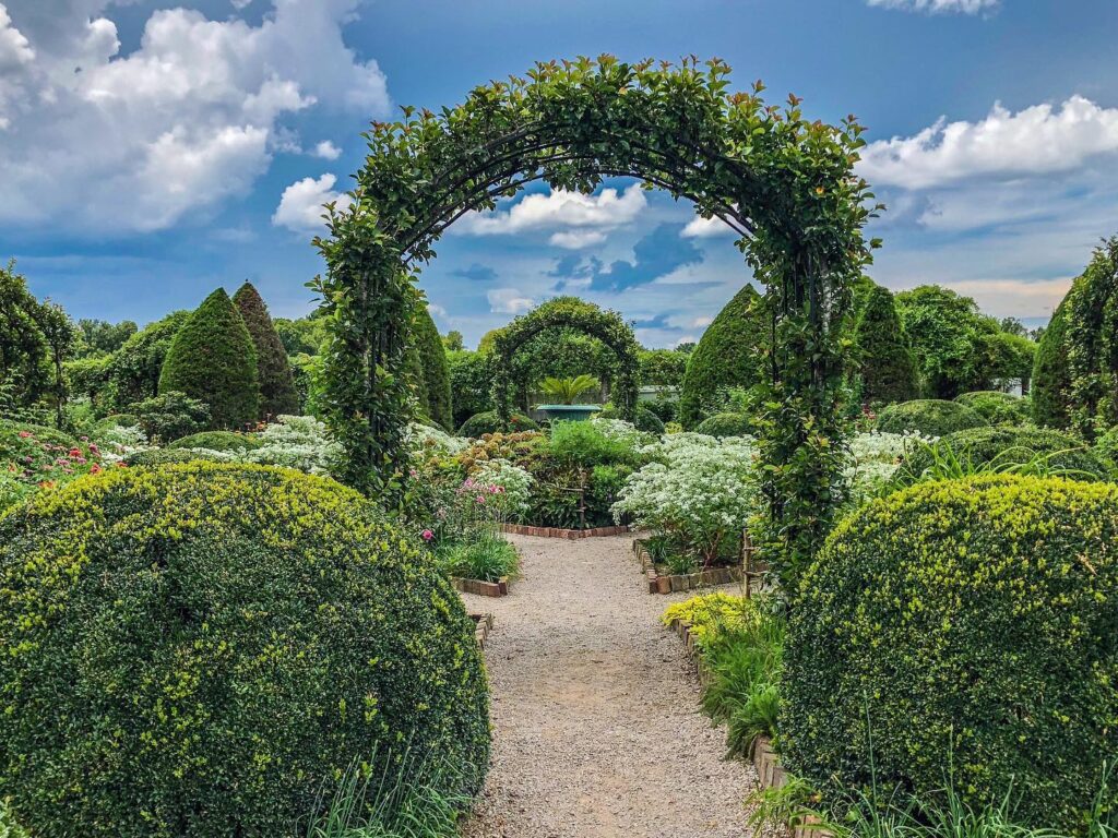 Franklin's 7 Most Photographed Spots A gravel path winds through a lush garden with neatly trimmed hedges and arches in Williamson County, Tennessee.