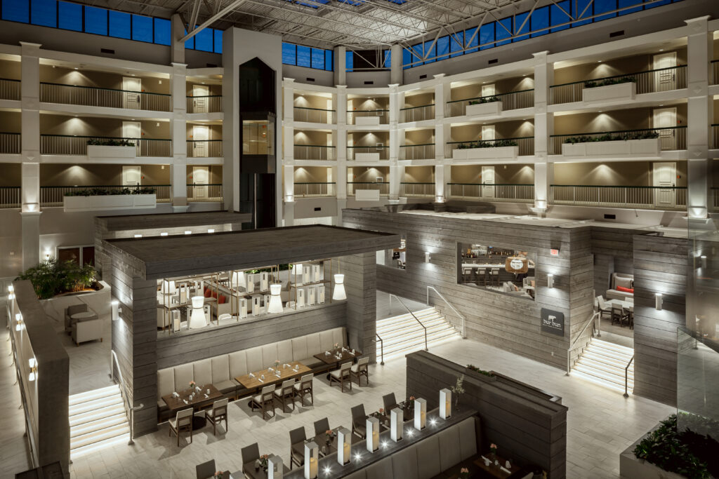 A modern hotel atrium with multiple levels, glass ceiling, and seating areas in Williamson County, Tennessee.