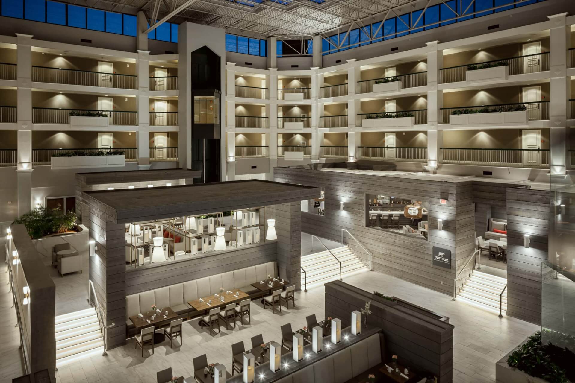 Hilton Brentwood/Nashville Suites A modern hotel atrium with multiple levels, glass ceiling, and seating areas in Williamson County, Tennessee.