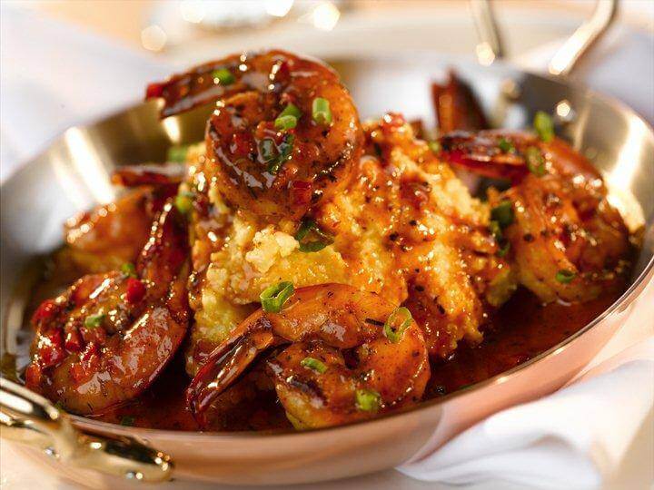A copper skillet filled with creamy grits topped with succulent, saucy shrimp and green onions in Williamson County, Tennessee.