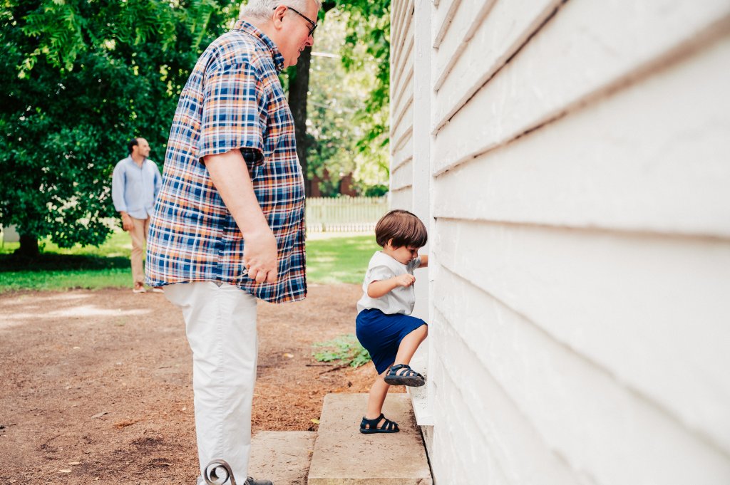Discover 12 Fun Things To Do With Young Kids in Franklin, TN A young boy, guided by his grandfather, carefully climbs the steps to a white wooden building while another man watches from a distance in Williamson County, Tennessee.