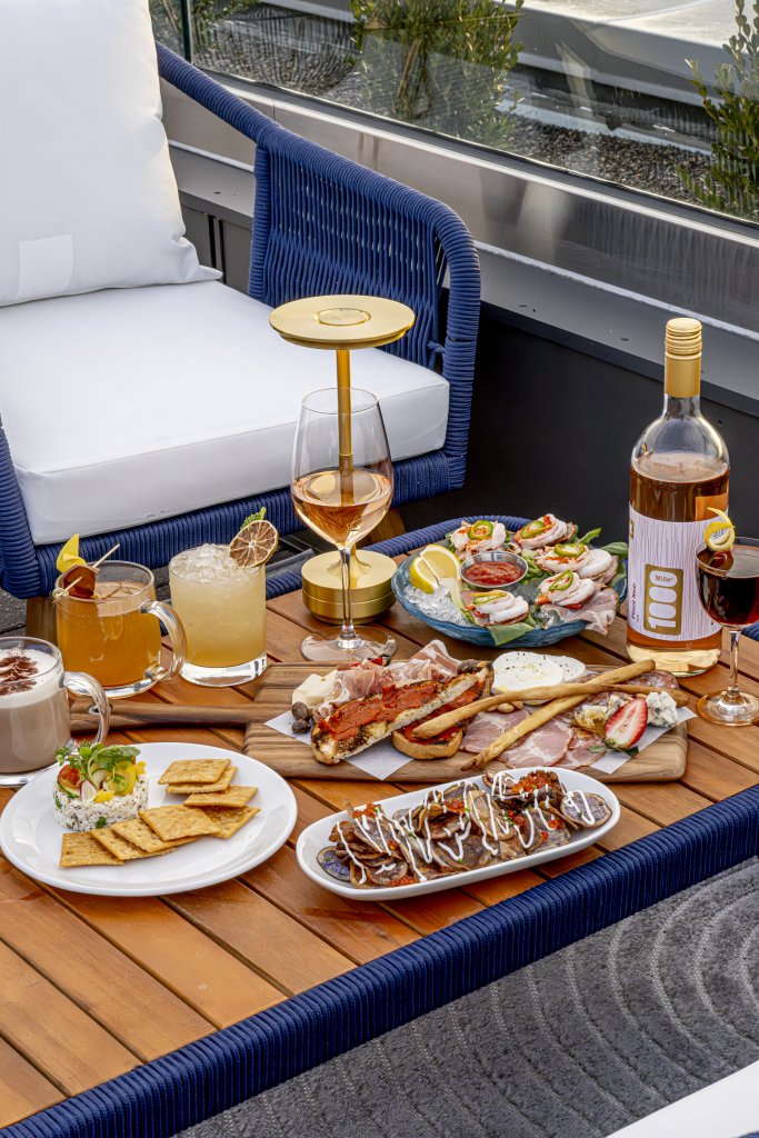 Celebrate Patio Season at Some of Franklin's Best Outdoor Dining Experiences A luxurious outdoor dining setup with a variety of gourmet appetizers, cocktails, and wine on a wooden table in Williamson County, Tennessee.