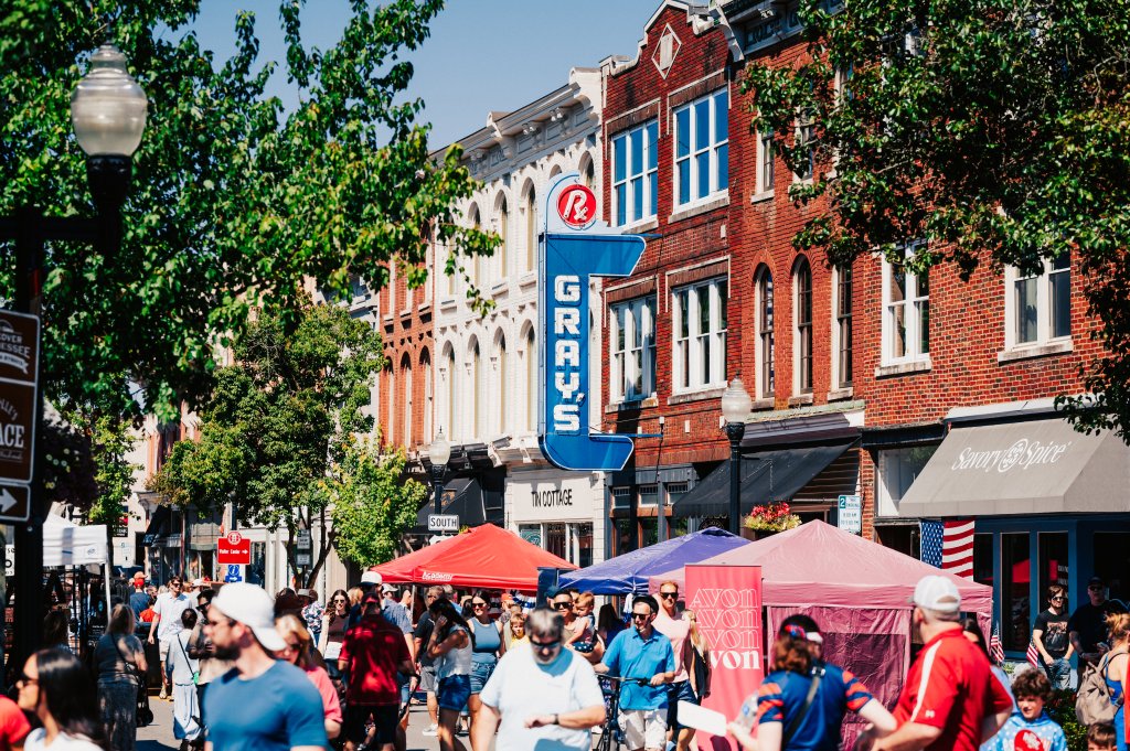 Let's Get Festive! Here Are the Essential Summer Events in Franklin, Tennessee A bustling downtown street filled with people shopping and dining under colorful umbrellas on a sunny day in Williamson County, Tennessee.