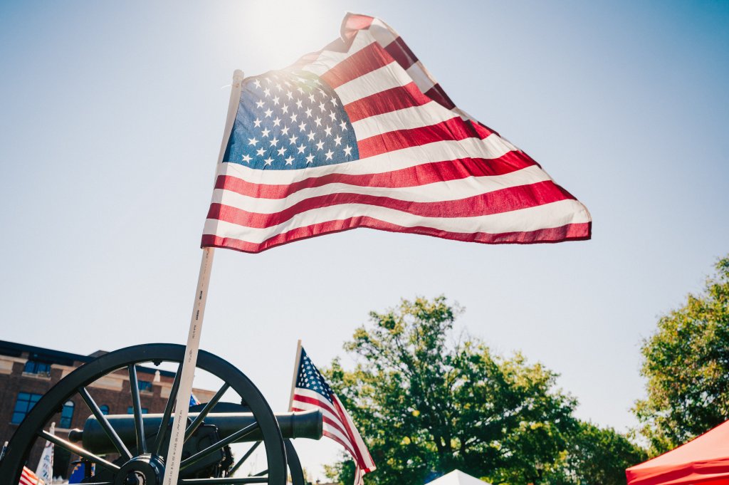 Franklin, Tennessee's Preservation Success Story A vibrant American flag waves proudly atop a historic cannon, bathed in warm sunlight against a clear blue sky in Williamson County, Tennessee.