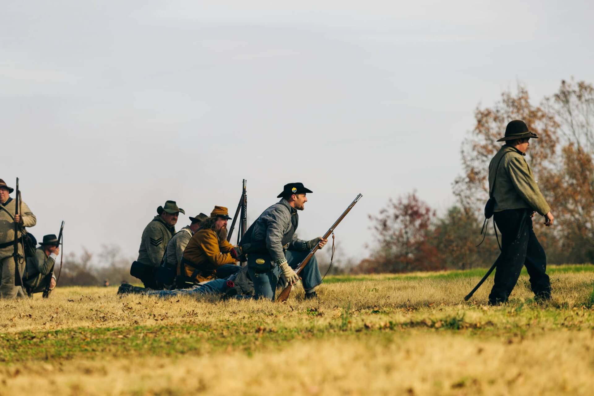 Civil War reenactors in period uniforms march across a grassy field with rifles in Williamson County, Tennessee.
