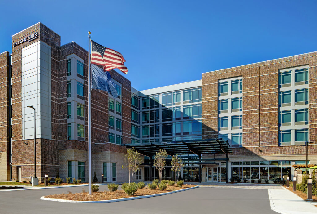 Modern hotel with brick facade, glass windows, and American flag flying high in Williamson County, Tennessee.