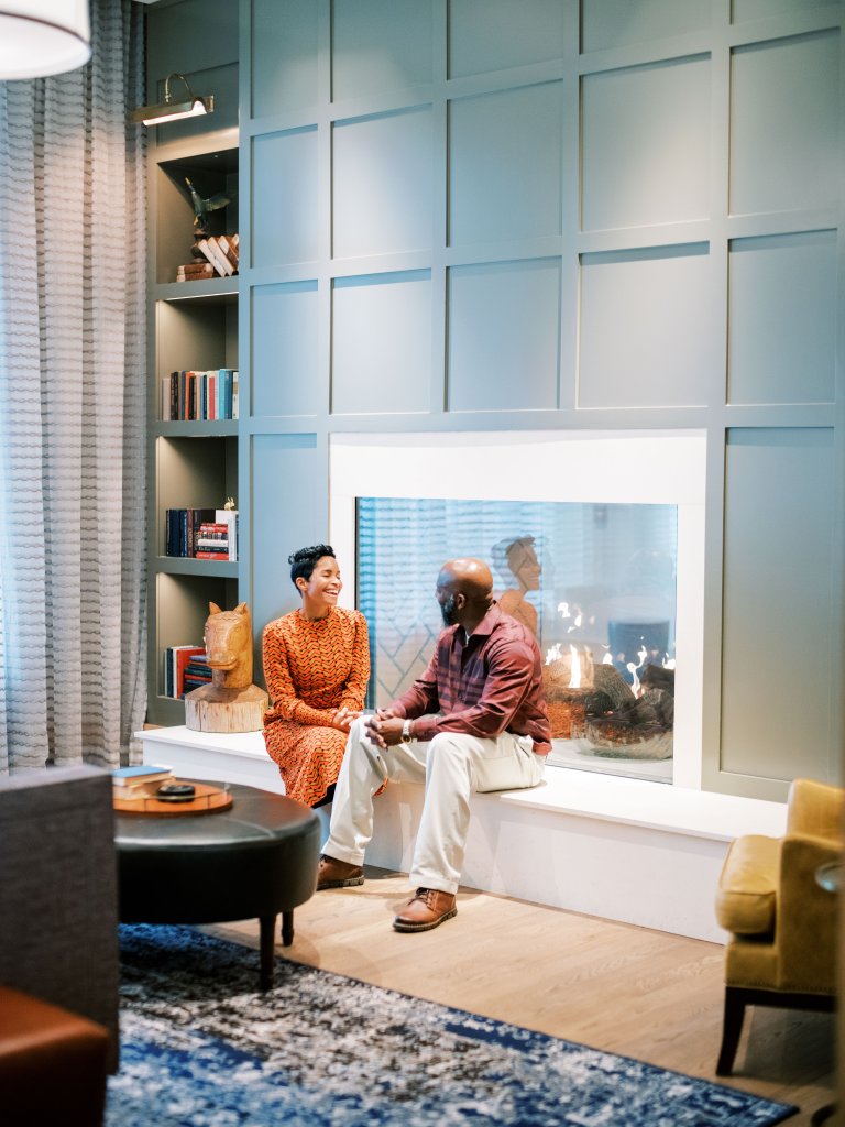 A couple enjoys a cozy conversation by a fireplace in a stylish living room in Williamson County, Tennessee.