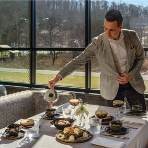 Countryside Brunch A man in a suit pours coffee at a table set with various dishes and drinks in Williamson County, Tennessee.