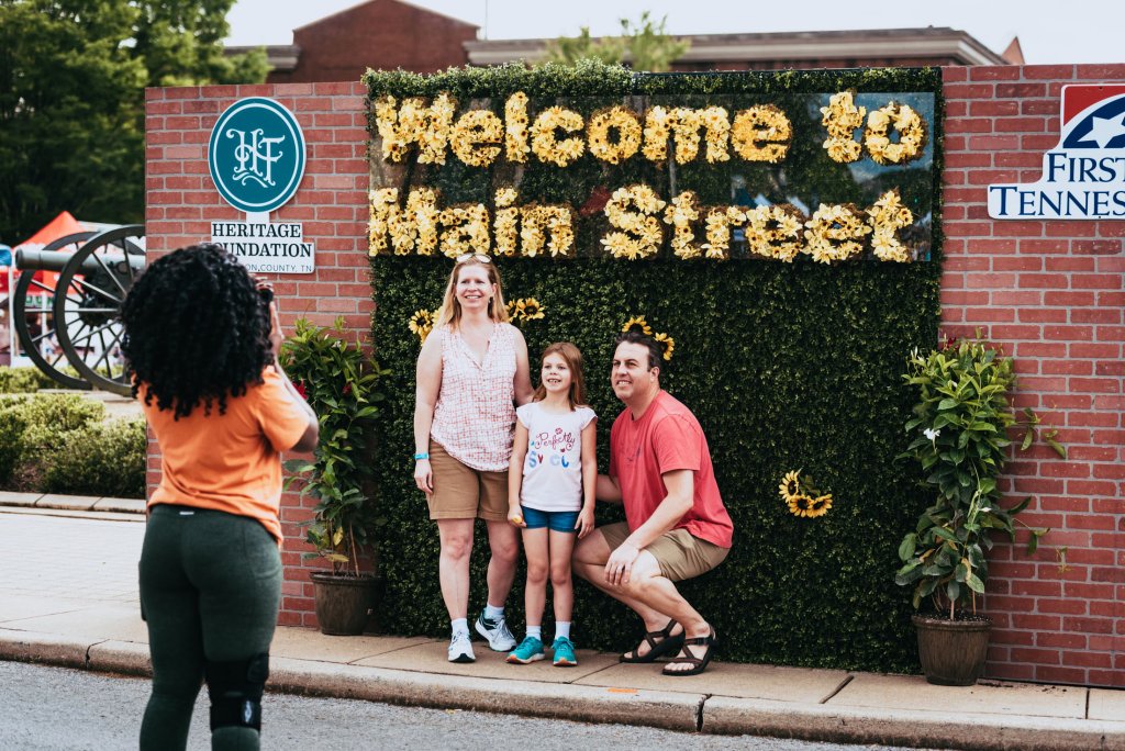 Main Street Festival A family of four poses for a photo in front of a floral welcome sign on Main Street in Williamson County, Tennessee.