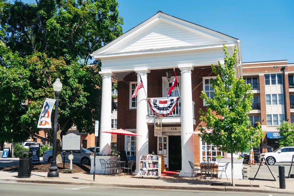Franklin, Tennessee's Preservation Success Story A charming brick building with white columns and American flags, surrounded by trees and outdoor seating in Williamson County, Tennessee.
