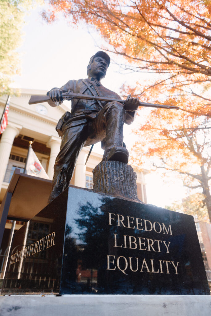 A bronze statue of a soldier with a rifle stands on a pedestal inscribed with 'Freedom, Liberty, Equality' in Williamson County, Tennessee.