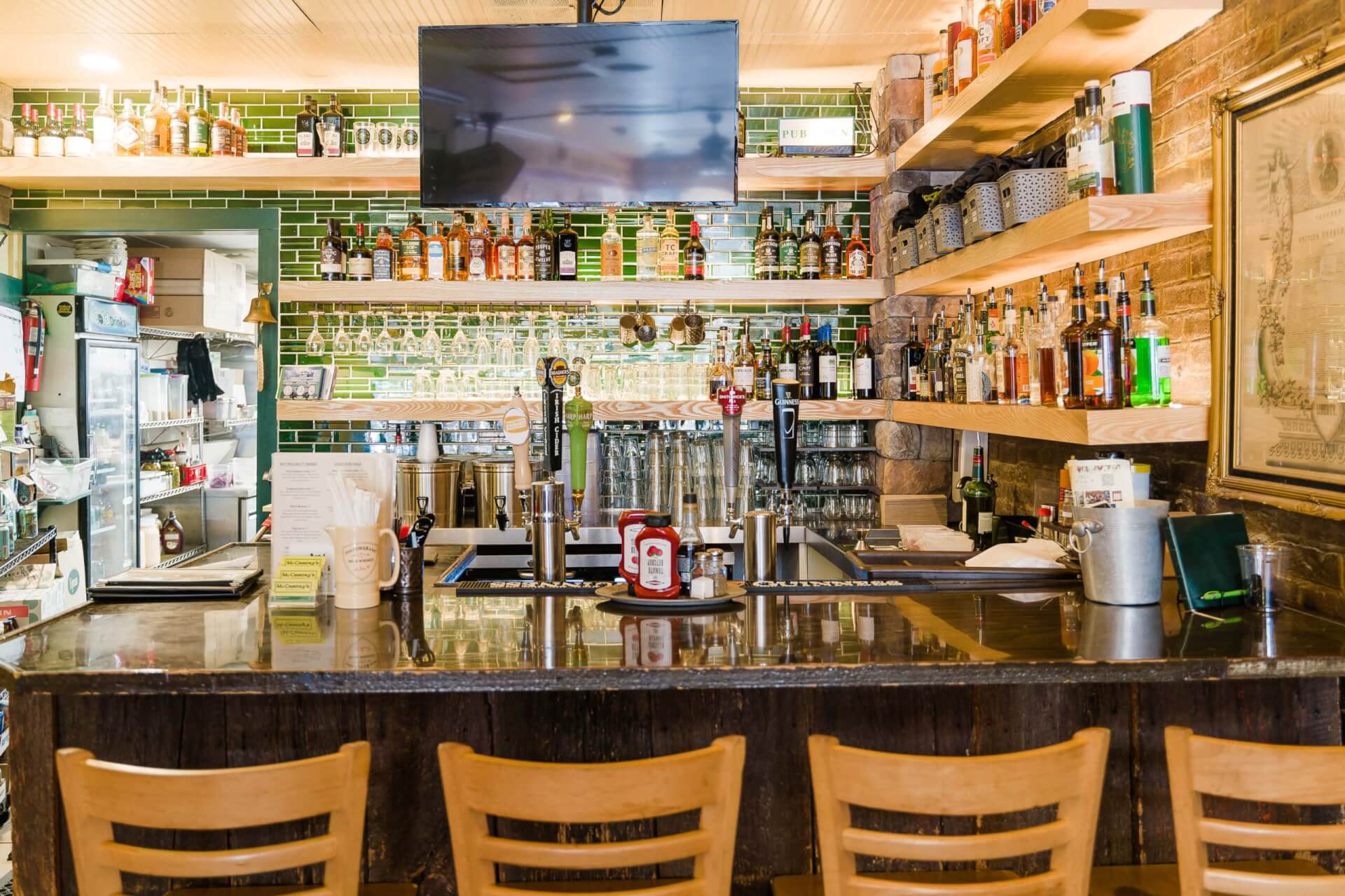 A cozy bar with wooden chairs, a brick wall, and shelves stocked with various bottles of alcohol in Williamson County, Tennessee.