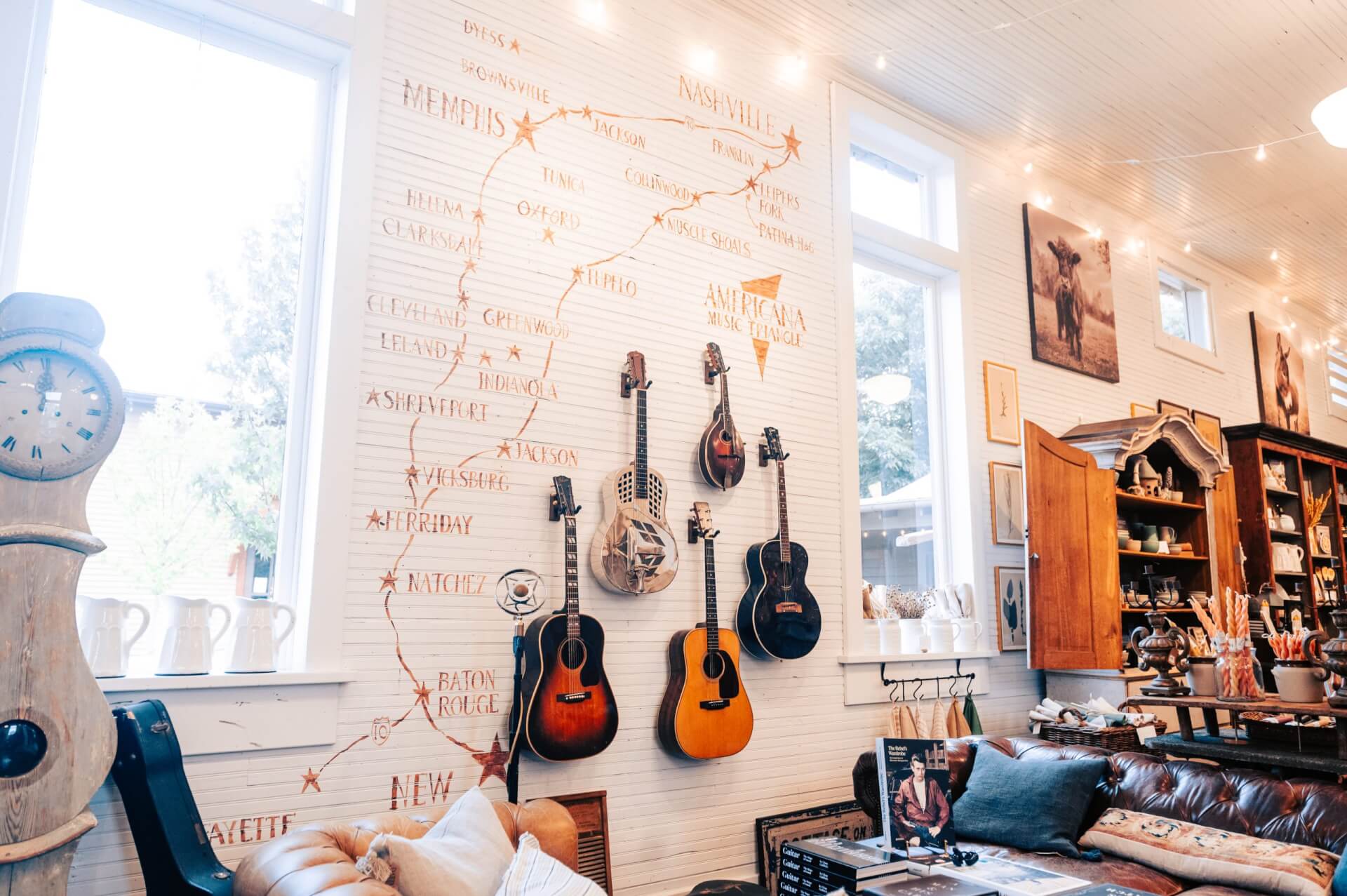 A cozy room with guitars on the wall, a leather couch, and a large window in Williamson County, Tennessee.