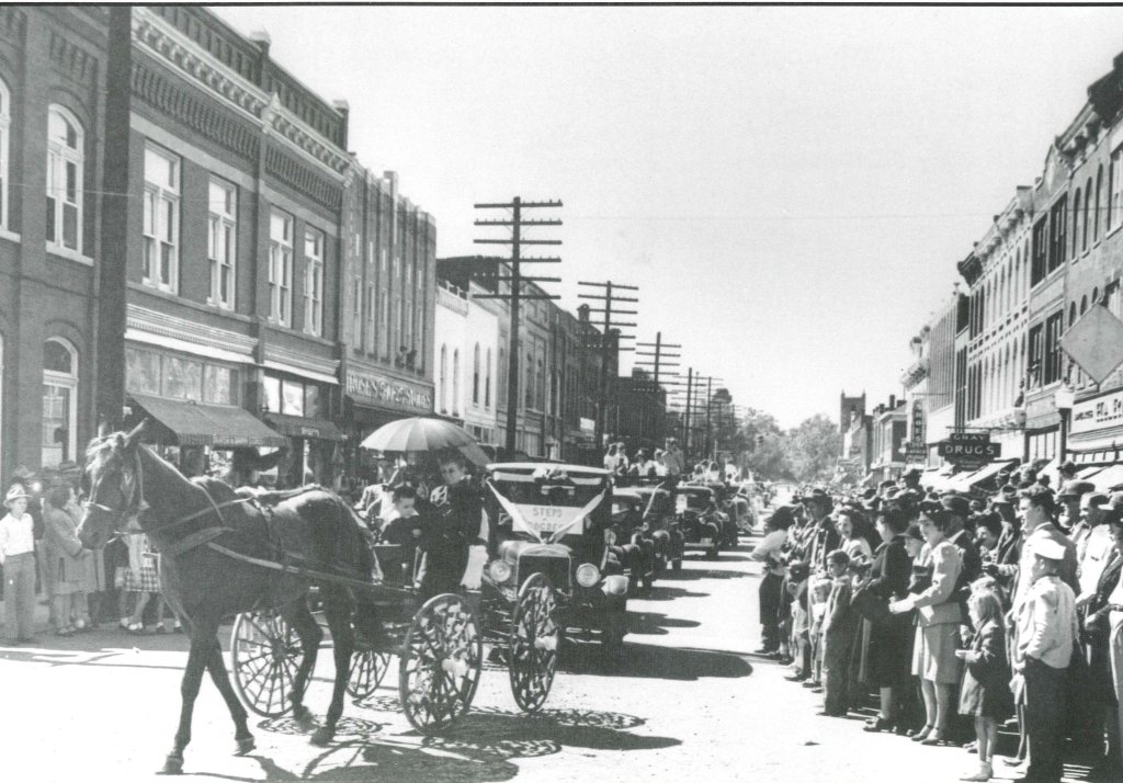 Franklin, Tennessee's Preservation Success Story A bustling town square filled with people, horse-drawn carriages, and early 20th-century automobiles during a parade or celebration in Williamson County, Tennessee.