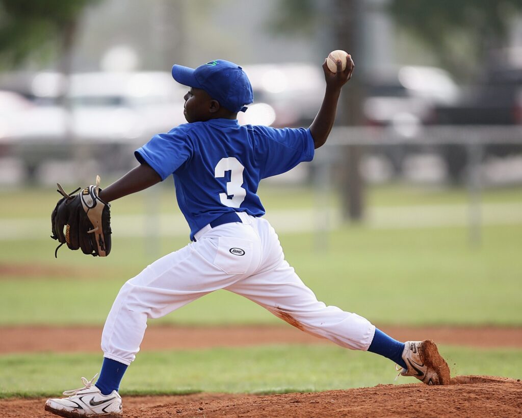 A young baseball player in a blue uniform is pitching a ball on a baseball mound in Williamson County, Tennessee.