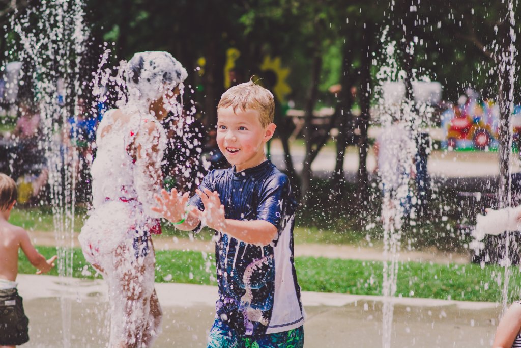 Splash Days Children joyfully play in a water fountain on a sunny day, getting soaked and laughing in Williamson County, Tennessee.