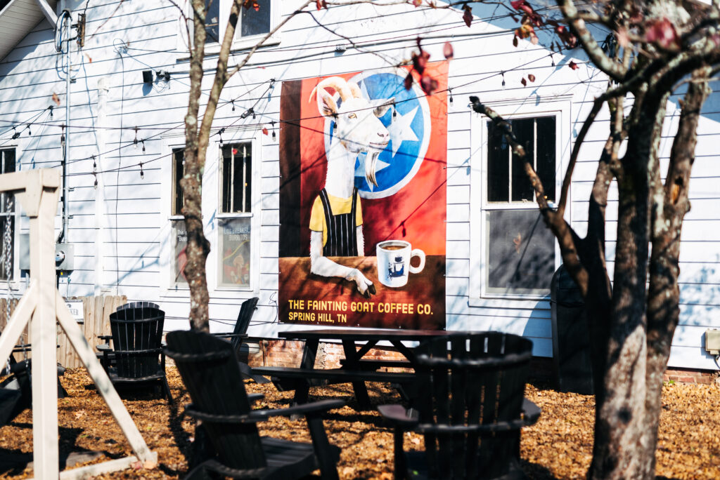 A mural of a goat holding a coffee mug adorns the side of a white building in Williamson County, Tennessee.