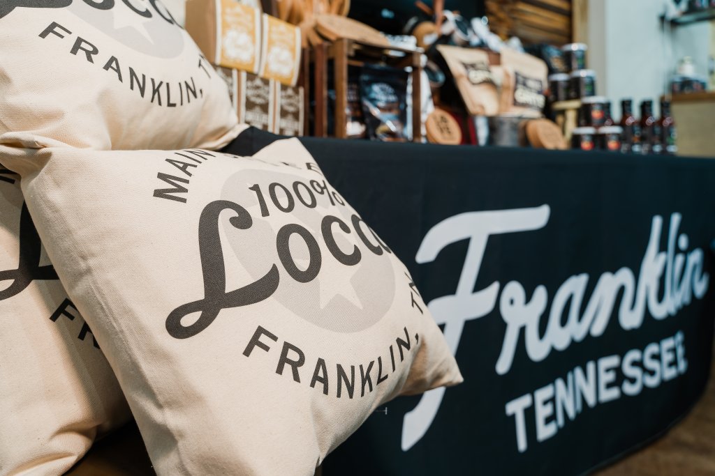 A display of branded merchandise including pillows and a tablecloth in Williamson County, Tennessee.