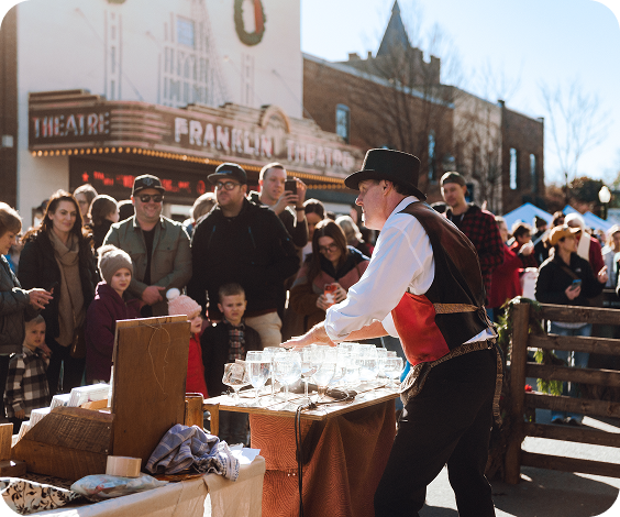Dickens of a Christmas A street performer in period costume entertains a crowd with glassware tricks outside a vintage theater in Williamson County, Tennessee.