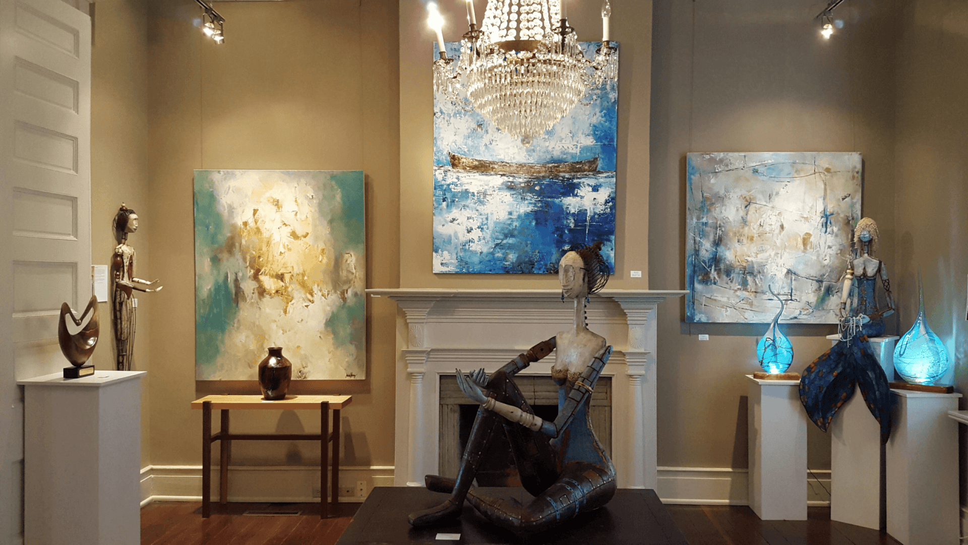 Gallery 202 Art gallery with abstract paintings, sculptures, and a chandelier over a fireplace in Williamson County, Tennessee.