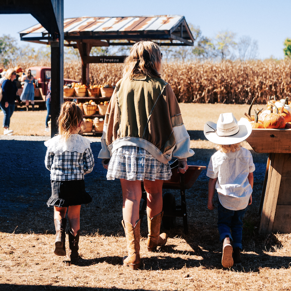 How Williamson County’s Farms Draw in Visitors and Keep History Alive A family of three, dressed in cowboy attire, walks through a pumpkin patch on a sunny day in Williamson County, Tennessee.