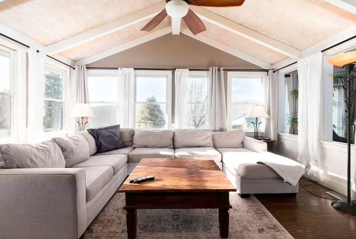 A spacious living room with a high ceiling, large windows, and a comfortable sectional sofa in Williamson County, Tennessee.