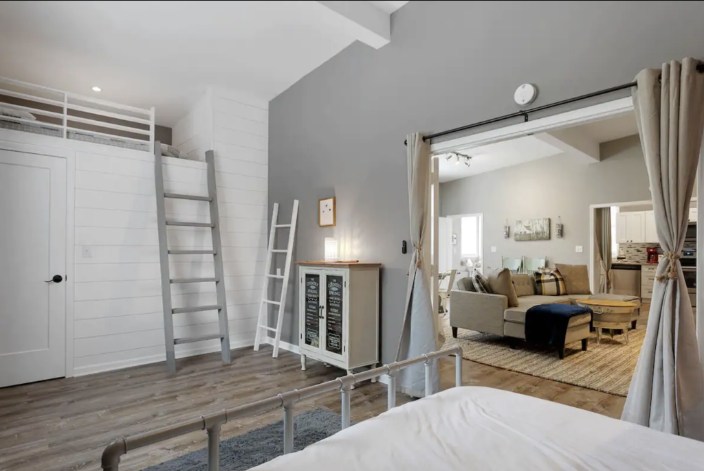 A modern, open-concept living space with a loft area, cozy furniture, and rustic accents in Williamson County, Tennessee.