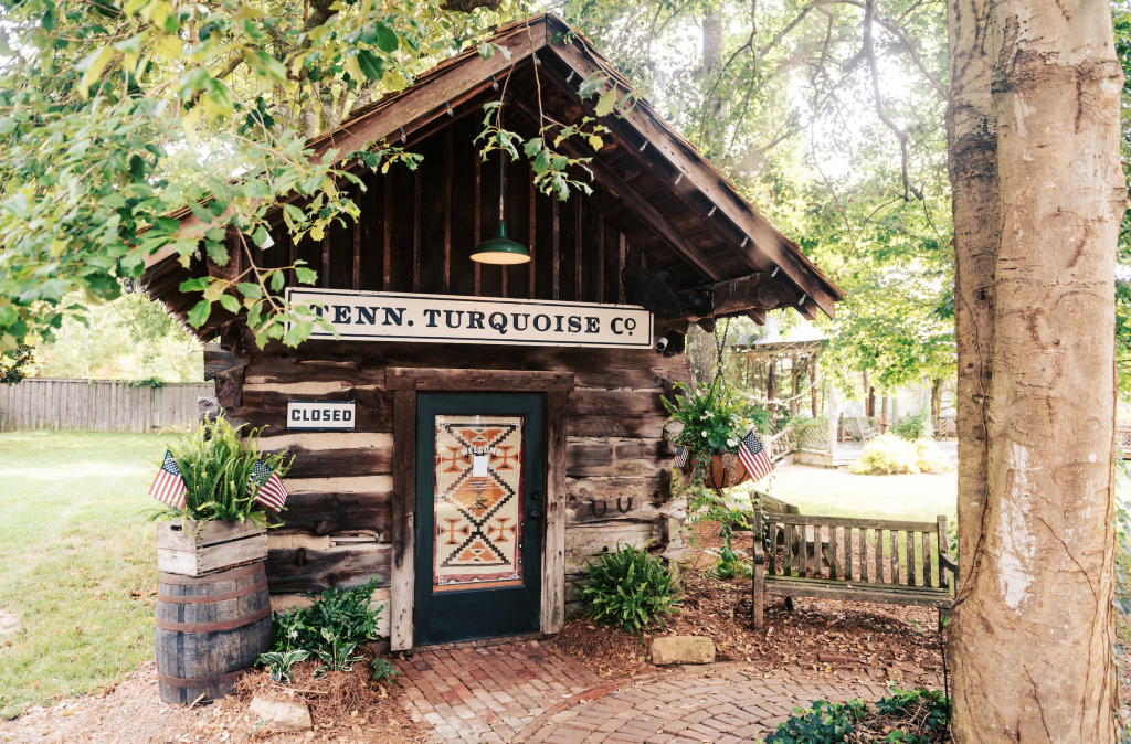 12 Amazing Things to Do in Charming Leiper's Fork, Tennessee A rustic wooden cabin with a sign reading 'Tenn. Turquoise Co.' and a closed door in Williamson County, Tennessee.