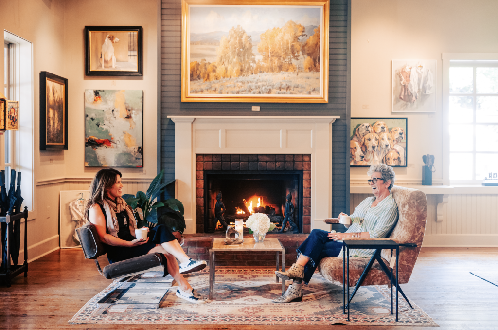 12 Amazing Things to Do in Charming Leiper's Fork, Tennessee Two women enjoy coffee by a fireplace in a cozy, art-filled living room in Williamson County, Tennessee.